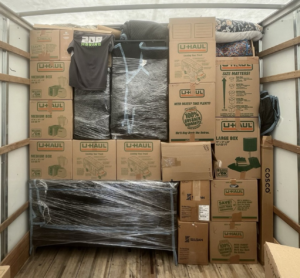 Properly loaded moving truck with stacked boxes and wrapped furniture secured for transport
