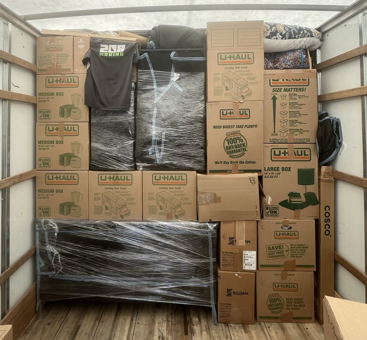 Properly loaded moving truck with stacked boxes and wrapped furniture secured for transport