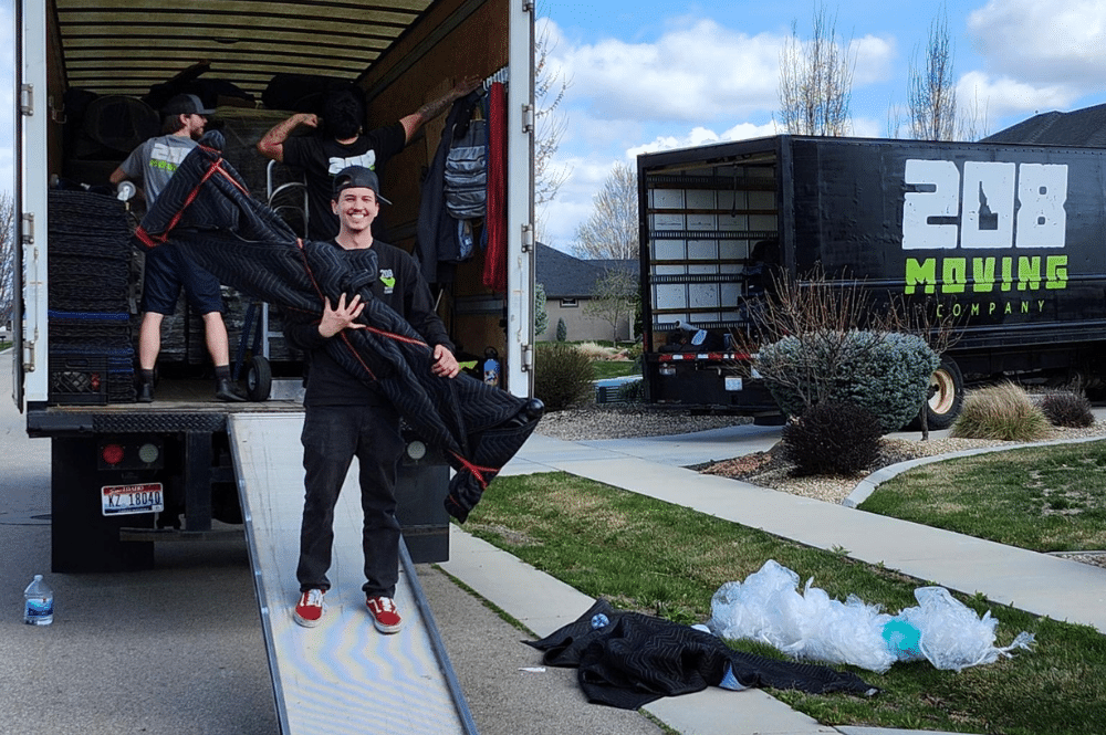 Two men in uniform are loading boxes into a moving truck, representing Boise movers in action.