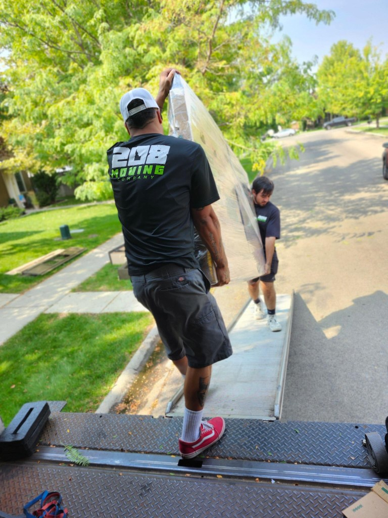 Boise residential movers carrying a mattress down a moving truck ramp