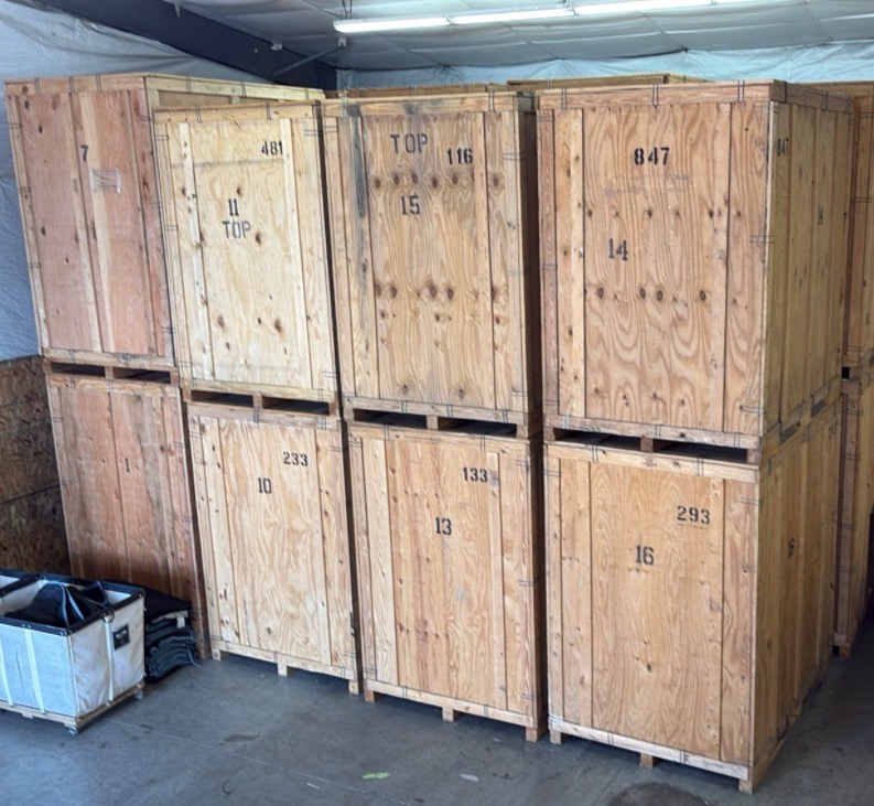 Stacked wooden storage vault crates inside a moving company warehouse used for secure household storage